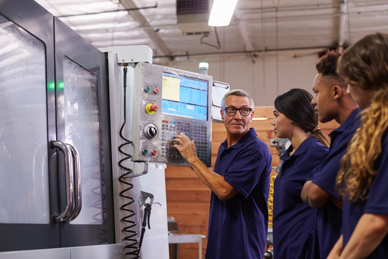 Engineers controlling CNC machine