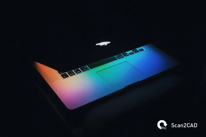 A Macbook partially closed in a dark room
